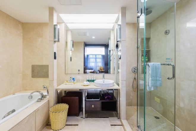 Ein modernes Badezimmer mit einer gläsernen Duschkabine, einer Badewanne und einem Waschtisch.