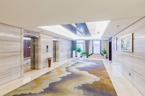 A modern hotel lobby with a marble floor, a central staircase, and potted plants. - ZTE Hotel, Nanjing (Nanjing)