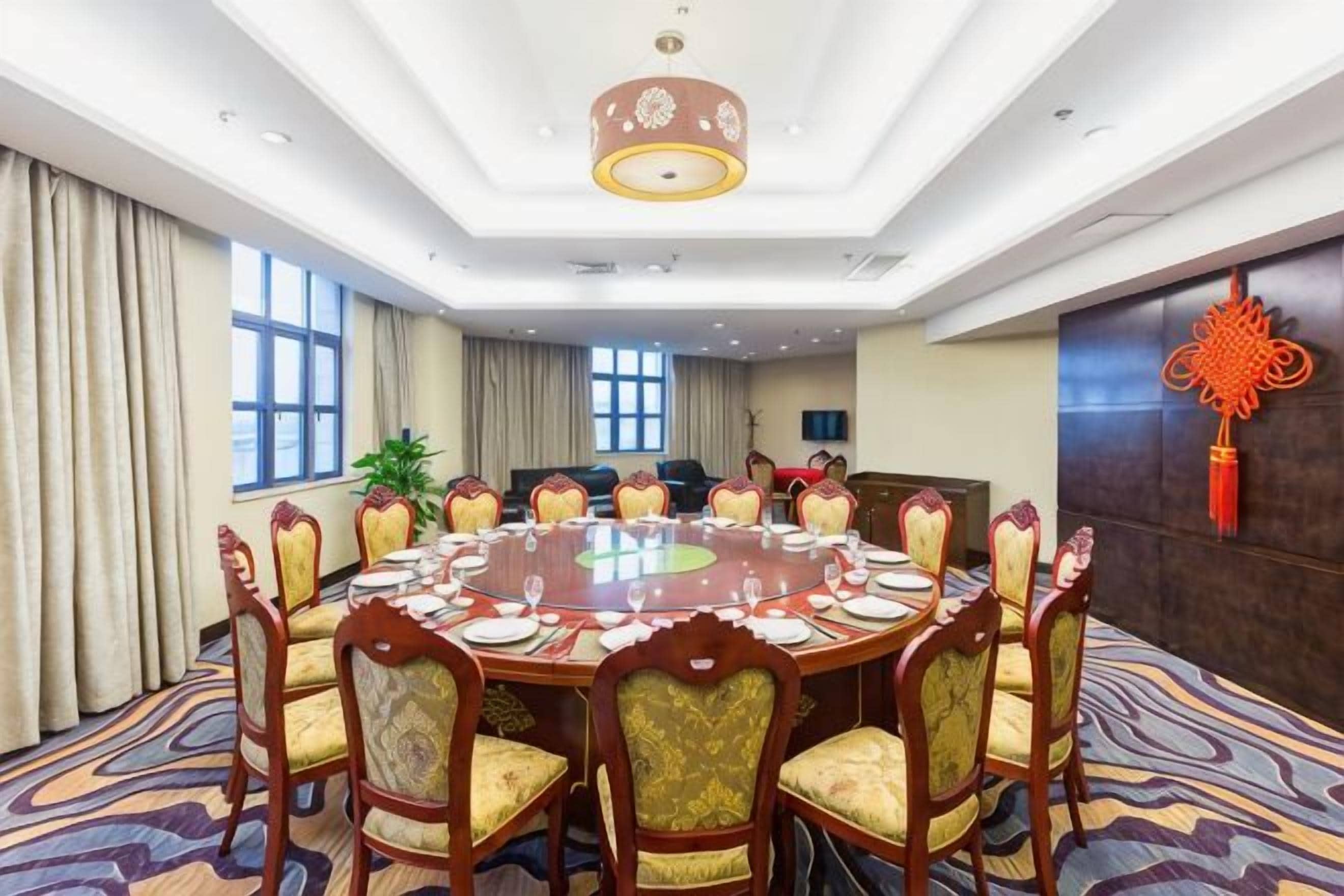A conference room with a round table, chairs, and a chandelier.