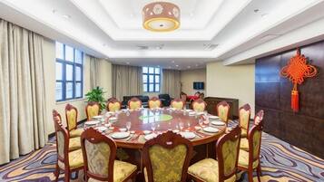 A conference room with a round table, chairs, and a chandelier.