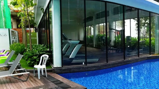 A modern building with a swimming pool, large glass windows, and outdoor seating. - Midhills at Genting by Self Check In (Genting Highlands)