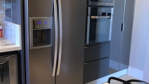 Eine moderne Küche mit Einbaukühlschrank, Backofen und Mikrowelle.