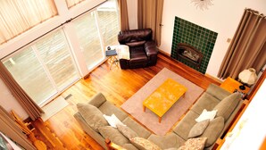 A living room with a sofa, a coffee table, and a fireplace. - Shearwater Beach Front Vacation Rental 3000 sqft (Depoe Bay)
