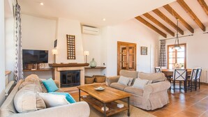 Una sala de estar amplia con chimenea, sofás, una mesa de centro y un comedor con sillas.
