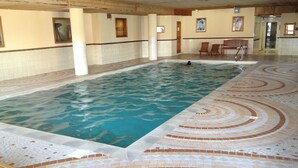 An indoor swimming pool with a tiled floor and wooden benches. - Arc 2000 Chalet, Peaceful Chalet By Slopes with Pool/Spa  (Bourg-Saint-Maurice)