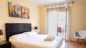 Een hotelkamer met een bed, een stoel, een tafel en kunst aan de muur.