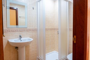 A bathroom with a sink, mirror, and shower enclosure. - 3 bedroom villa in family complex with pools (Corralejo)