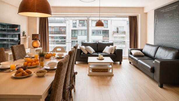Ein modernes Wohnzimmer mit Essbereich, einer Couch, einem Couchtisch und einem großen Fenster mit Blick auf Gebäude.