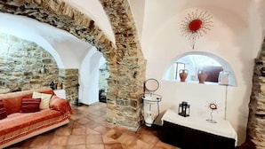 Ein gemütlicher Raum mit einer Steinwand, einem roten Sofa und einem weißen Tisch mit dekorativen Accessoires.