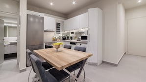 Une cuisine moderne avec une table à manger, des chaises et un réfrigérateur.