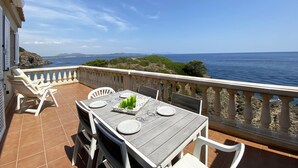 Terraço com uma mesa posta para dois, com vista para a costa.