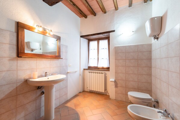 A bathroom with a sink, mirror, toilet, and window. - Beautiful Tuscan farmhouse in the countryside with swimming pool (Mercatale)