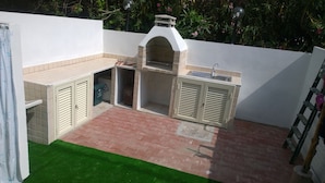 A compact outdoor kitchen area with a built-in grill, a sink, and storage cabinets. - San Teodoro: 600 m. from the beach and the center, air conditioning, Wi-Fi  (San Teodoro)