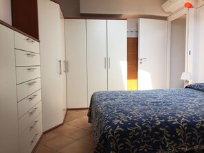 Une chambre à coucher avec un lit, une armoire et une table de chevet.