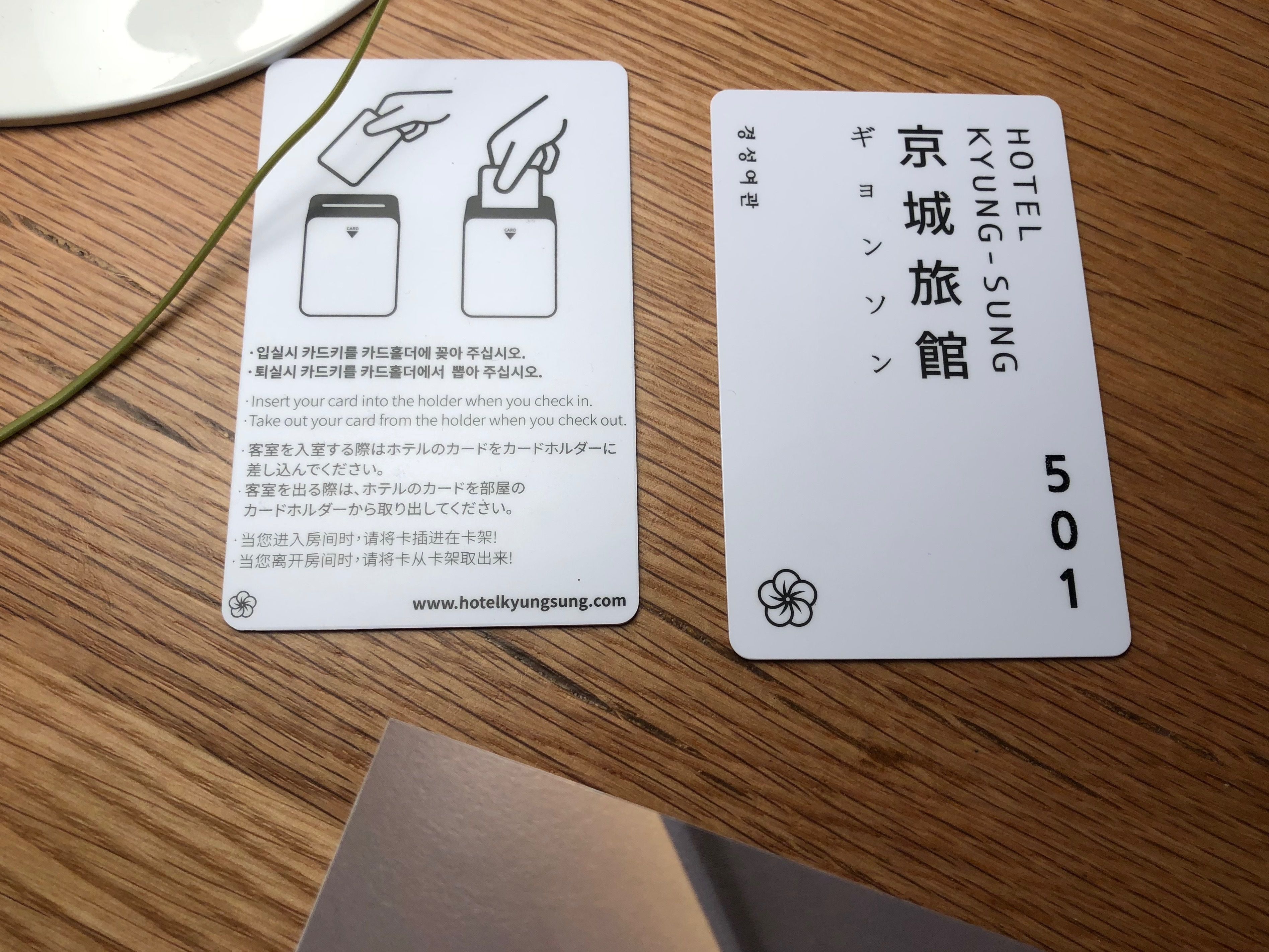 Dos tarjetas: una con indicaciones en japonés y otra con datos del hotel en coreano.