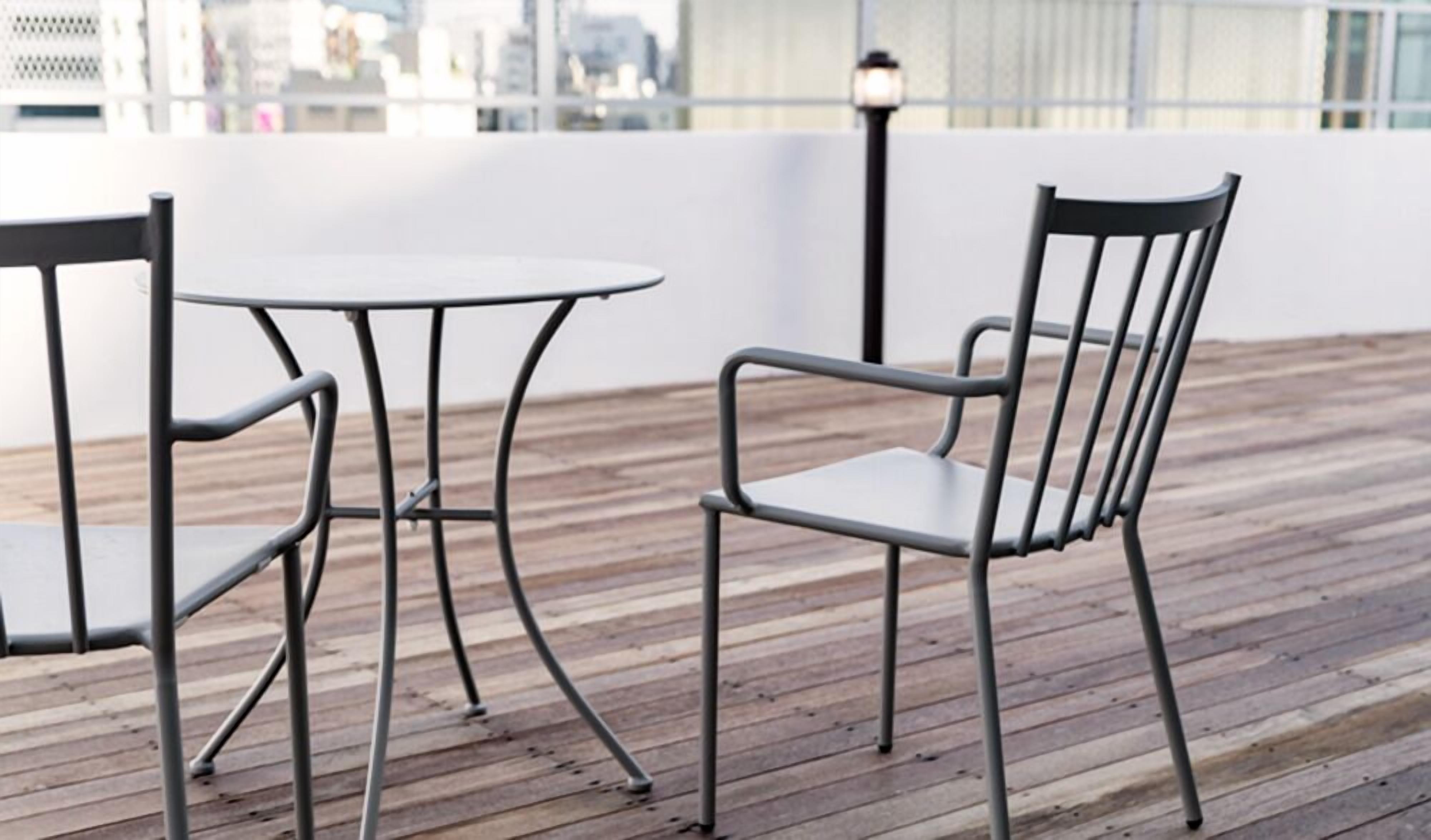 A wooden deck with metal chairs and a table.