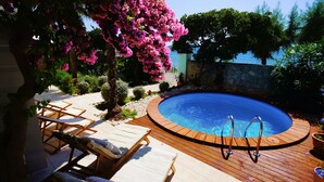 Ein Swimmingpool mit Holzliegen und einer umlaufenden Holzterrasse.