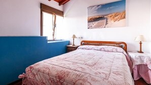A bedroom with a bed, a window, a painting, and a nightstand. - Apto Tapia 2 - rural apartment in Luces (Colunga), Northern Spain | 6 guests (San Telmo)