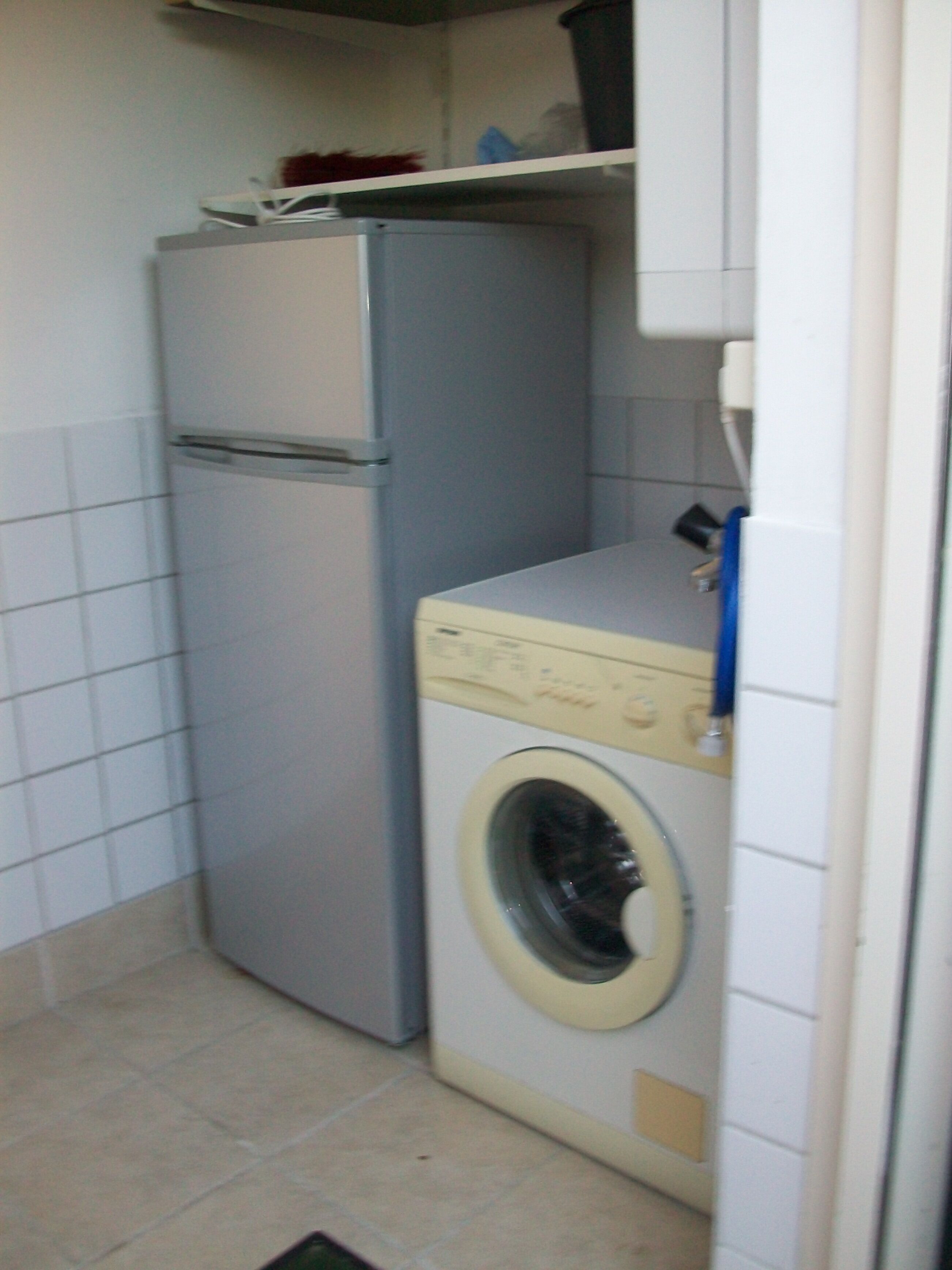 Eine kleine Küche mit Kühlschrank und Waschmaschine.