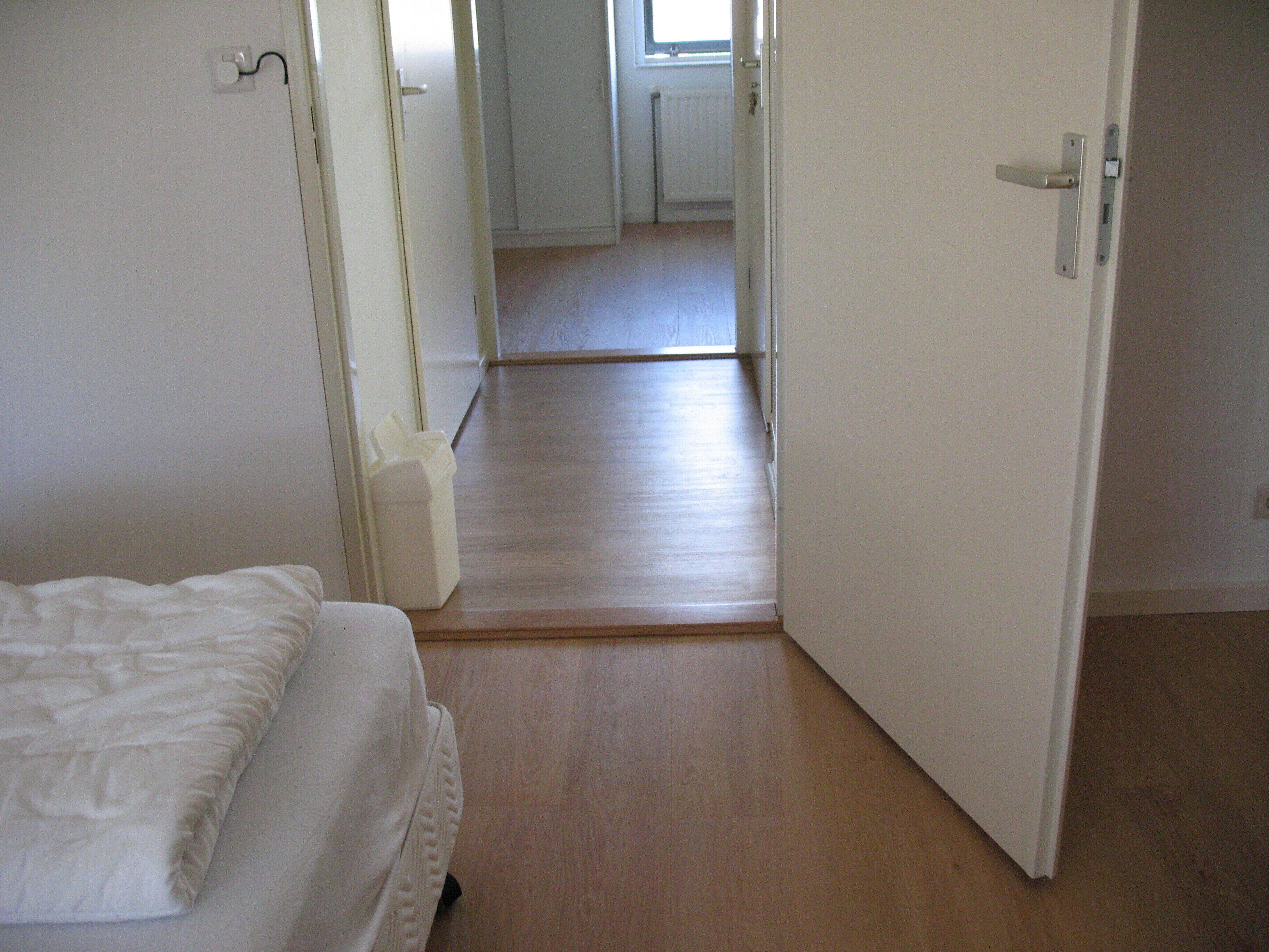 Ein Schlafzimmer mit einem Bett, einem Nachttisch und einer weißen Steckdose.