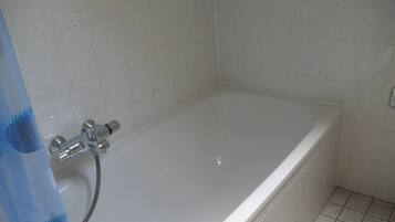 A bathroom with a bathtub, a shower, and a toilet.