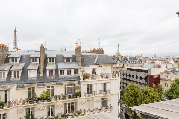 A row of European-style buildings with varying rooflines and balconies, some with plants. - Views to the Eighth, by Veeve (Paris)