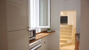 A kitchen with a window, a microwave, and a wooden countertop. - Luxurious relaxation in town! (Napoli)