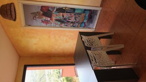 Una habitación con un ventanal grande, una mesa con sillas y un cuadro en la pared.