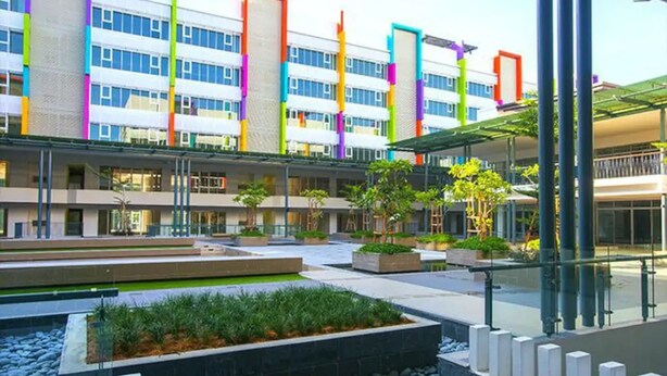 A modern building with multiple floors, outdoor seating areas, and a well-maintained garden. - Stay Awhile at Aeropod Sovo Studio (Kota Kinabalu)