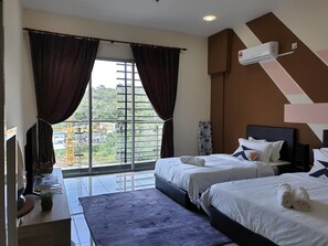 A hotel room with two beds, a large window with curtains, a flat-screen TV, a desk with a plant, and a view of construction outside. - Stay Awhile at Aeropod Sovo Studio (Kota Kinabalu)