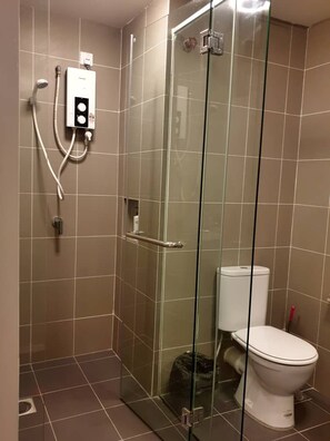 A glass-enclosed shower stall with a white toilet and a control panel. - Stay Awhile at Aeropod Sovo Studio (Kota Kinabalu)