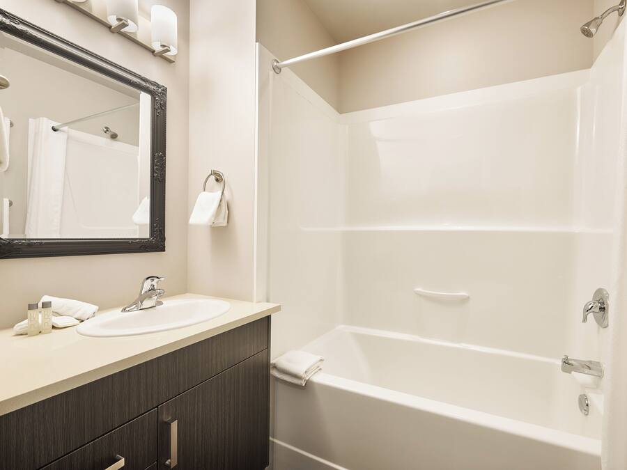 Un baño con bañera, lavabo y espejo.