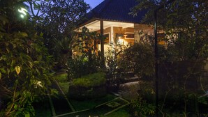 Ein traditionelles Haus mit Ziegeldach, umgeben von üppigem Grün und einem gepflegten Garten.