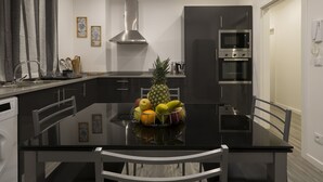 Une cuisine moderne dotée d’un îlot central, d’appareils électroménagers en acier inoxydable et d’un panier à fruits.