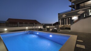 Une piscine sur le toit offrant une vue sur le paysage urbain au crépuscule.