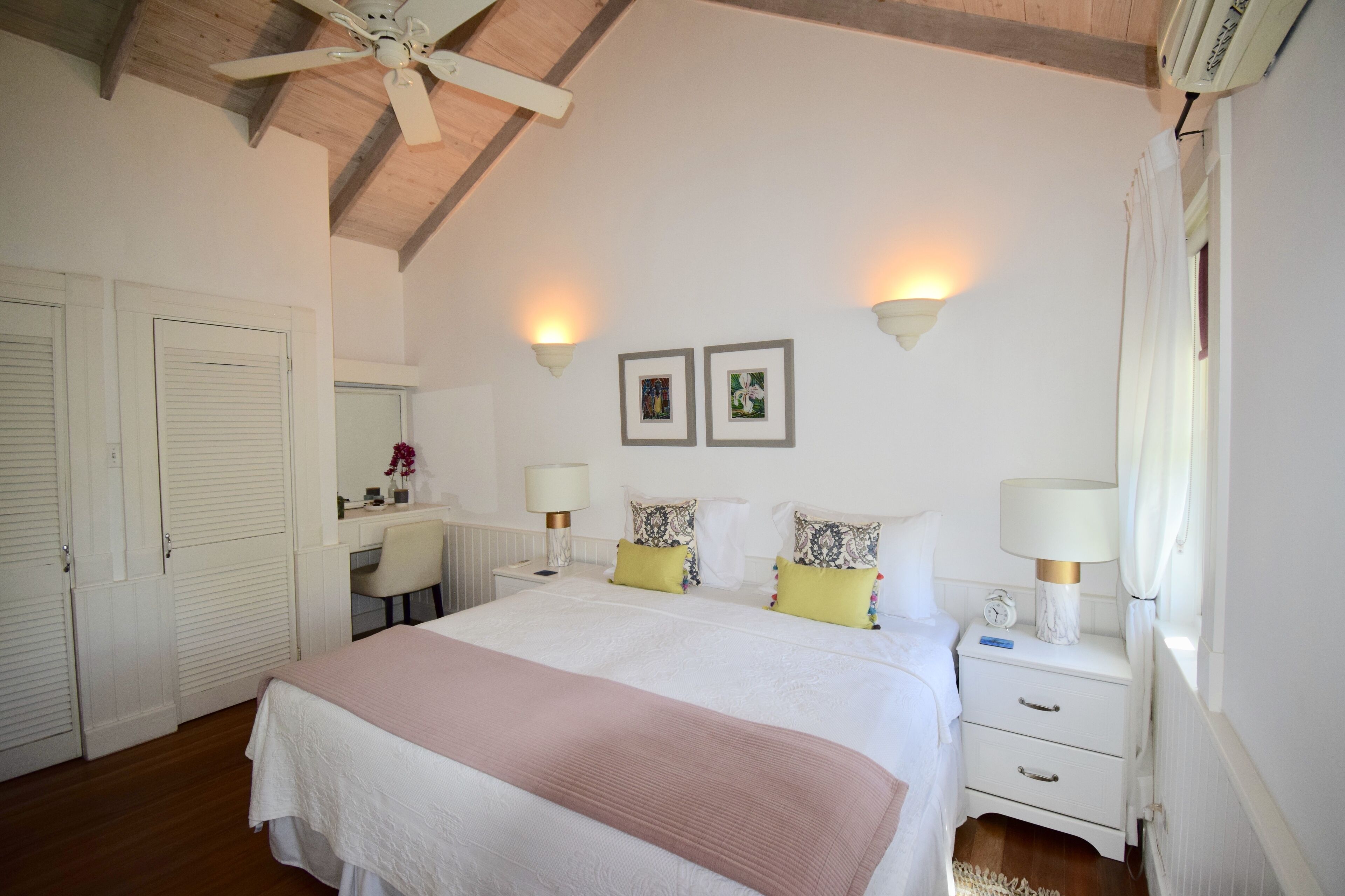 Een slaapkamer met een bed, nachtkastjes, een bureau en een stoel.