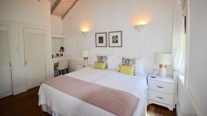 Un dormitorio con una cama, mesitas de noche, un escritorio y una silla.