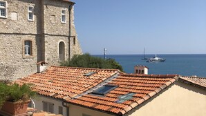 Ein Gebäude aus Stein mit einem Ziegeldach mit Blick auf das Meer.