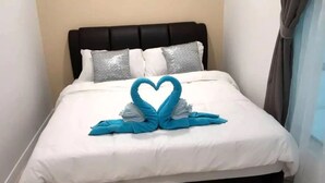 A neatly made bed with a heart-shaped towel arrangement in the center. - Comfy Home at Sutera Avenue (Kota Kinabalu)