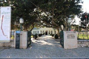 A cobblestone pathway leading to a building with a sign for Museu do Mar.