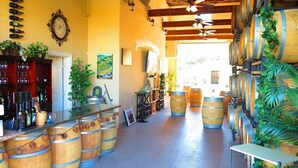 A wine cellar with wooden barrels, a wine rack, and a rustic interior design. - Sunshine Mountain Bed and Breakfast (San Marcos)