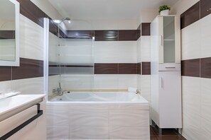 Tina, secadora de cabello, toallas, papel de baño 