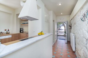 A modern kitchen with white cabinets, a marble countertop, and a fruit bowl. - Gardenia Garden House with beautiful sea views, near the beach and the village. (Sternes)