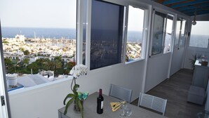 Ein Balkon mit Blick auf einen Hafen und das Meer.
