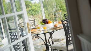 Una mesa de desayuno con frutas, croissants y zumo de naranja.