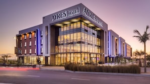 A modern hotel with a prominent sign reading "AYRES HOTEL".