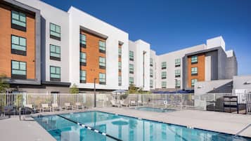 Relax by the inviting pool surrounded by lounge chairs and umbrellas.