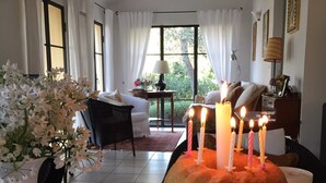 A room with a large window, a bed, a table with a cake and candles, and a vase with flowers. - Idyllically situated, comfortable detached country house in a stylish ambience (Dolcedo)