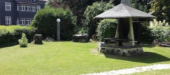 Modernly furnished bungalow with fireplace, surrounded by greenery.