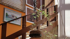 A staircase with wooden railings and stone walls, decorated with framed pictures and hanging plants. - Vista paradisiaca (Angra dos Reis)